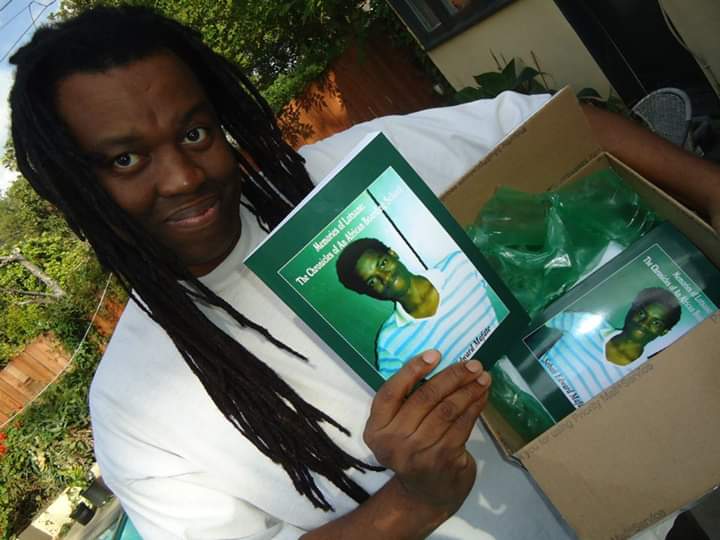 Sebati Edward Mafate holding a copy of Memories of Lotsane